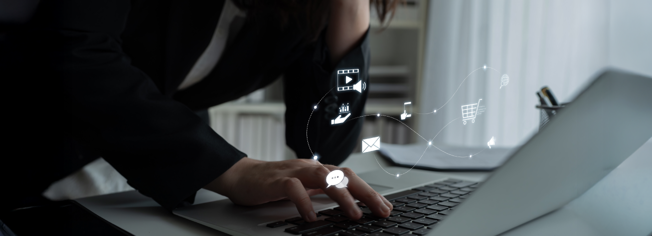 Person in black blazer works at a laptop.