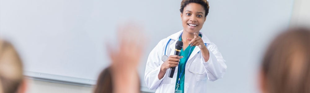 Medical professional with microphone calling on a student
