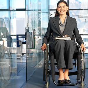 Professional public servant in business suit, smiling carrying books and sitting in wheelchair
