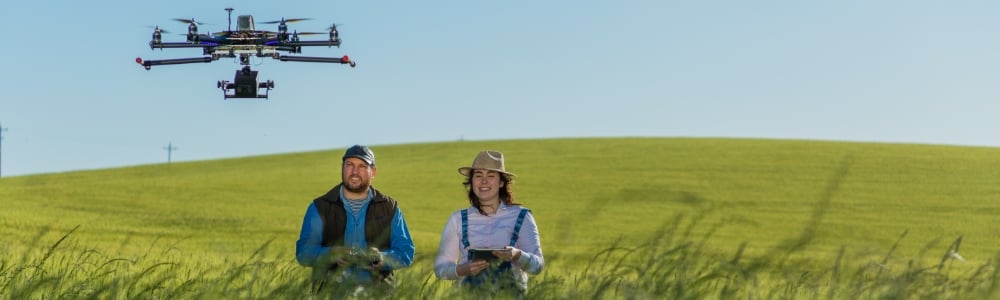 Farmers using drones in a field to elevate their work